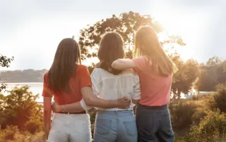 three young houston women in nature supporting each other through trauma