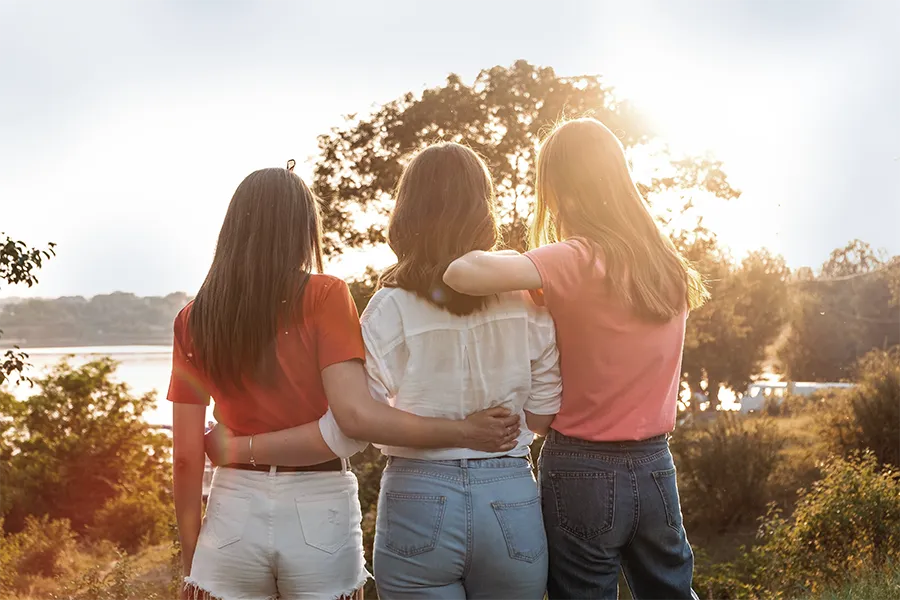 three young houston women in nature supporting each other through trauma