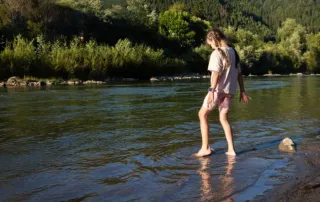 Young girl wading through a swamp - symbolic of moving forward through overwhelm and uncertainty - Houston Therapy for Girls